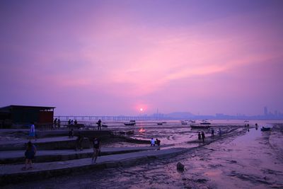 People at beach during sunset