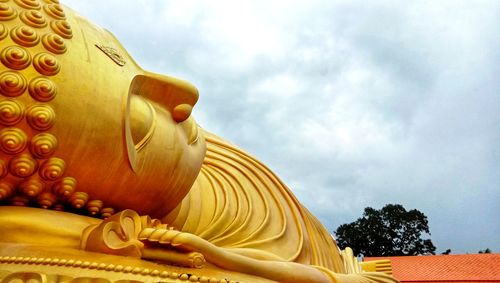 Low angle view of buddha statue against sky