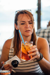 Close-up of woman holding drink in restaurant