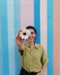 Portrait of woman holding red flower