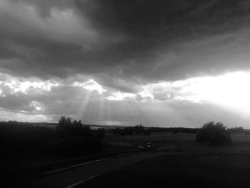 Country road against cloudy sky