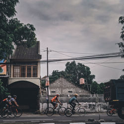 Bicycles on street by buildings in city against sky