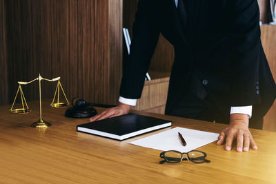 Midsection of man using laptop on table