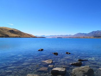 Scenic view of glaciale lake against clear blue sky