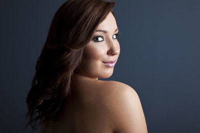 Portrait of a smiling young woman over black background