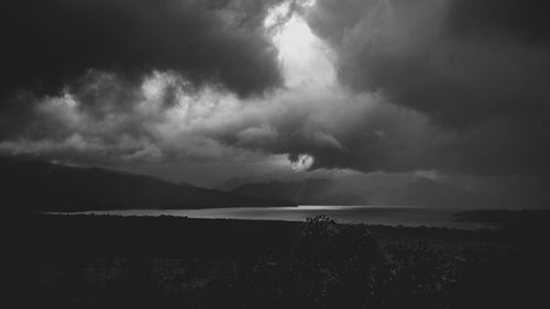 Scenic view of storm clouds over silhouette field