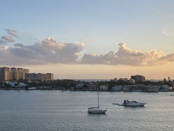 Scenic view of sea and buildings against sky during sunset