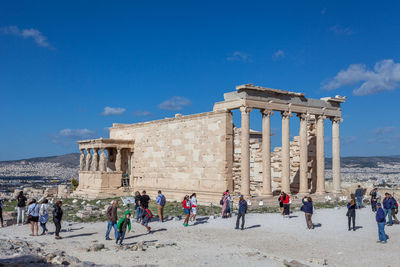 Tourists take photos of erechtheion in the acropolis in a windy day,  athens, greece