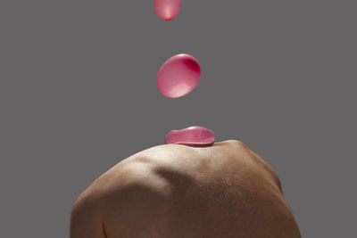 Rear view of shirtless man against black background