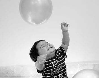 Cute boy playing with balloon at home