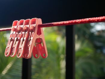 Close-up of clothespins hanging on rope