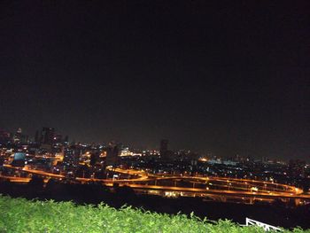 High angle view of illuminated cityscape against clear sky at night