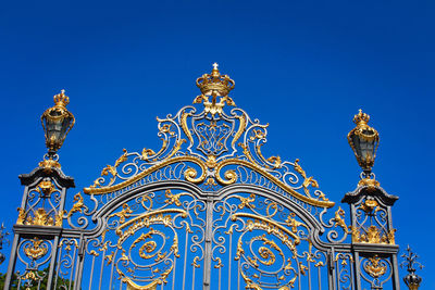 Low angle view of statue against building against clear blue sky