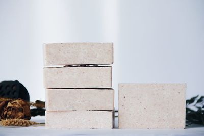 Close-up of soaps stacked against white background