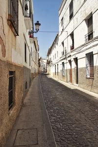Walkway amidst road in city against sky
