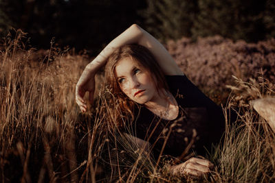 Portrait of a young woman lying on field