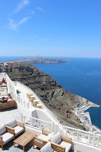 Open restaurants in santorini on cliff by sea against clear sky