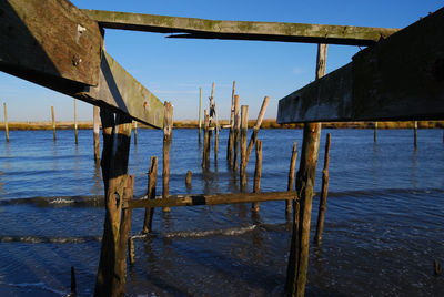 Wooden pier on lake against sky