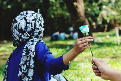 Midsection of woman holding umbrella on land