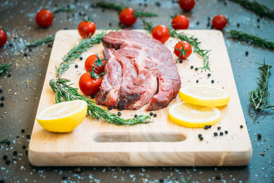 High angle view of meat with ingredients on cutting board