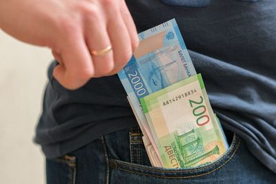 Midsection of man removing paper currencies from pocket