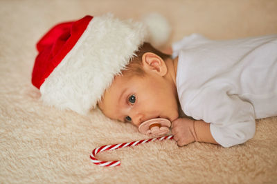 Close-up of baby boy lying on bed at home