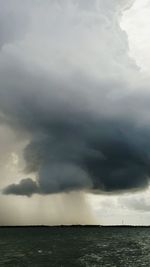 Scenic view of sea against storm clouds