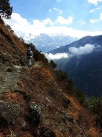 Rear view of hiker walking on mountain