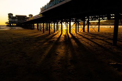 Pier over sea against sky during sunset