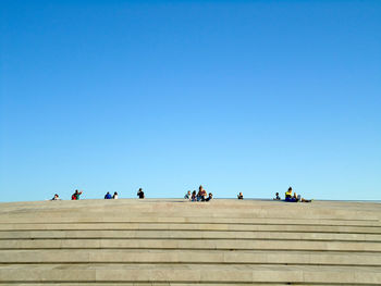 People against clear blue sky