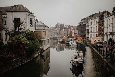 Canal amidst buildings against sky in city