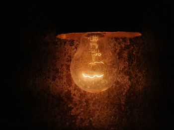 Close-up of illuminated light bulb in the dark