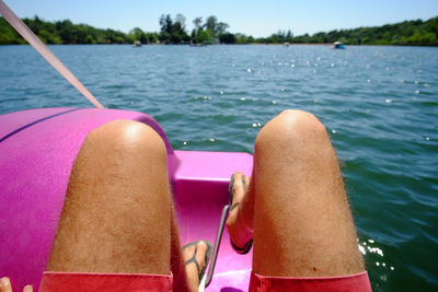 Low section of man in pedal boat on lake