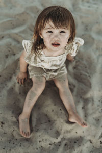 High angle view of young toddler girl looking at camera