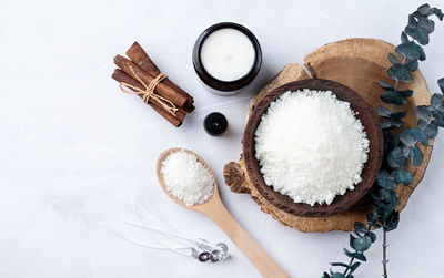 Ingredients for candle making , soy wax flakes, candles, cinnamon wicks and wooden 