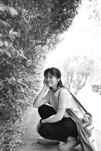 Side view of young woman sitting on field