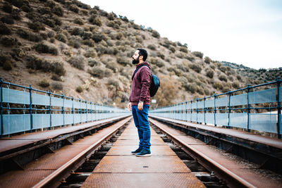 Man standing on railroad track against sky