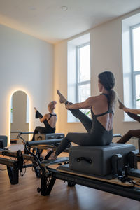 Side view of young woman sitting in gym