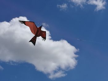 Low angle view of airplane flying against blue sky