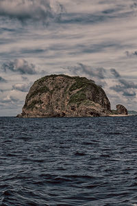 Rock formation in sea against sky