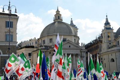 Low angle view of flags on building against sky