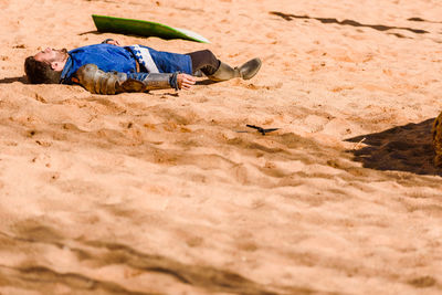 Boy sleeping on sand