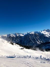 Scenic view of snowcapped mountains against clear blue sky