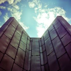 Low angle view of modern building against cloudy sky