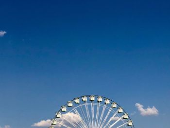 Low angle view of ferris wheel against blue sky