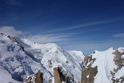 Scenic view of snowcapped mountains against blue sky