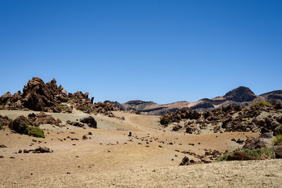 Scenic view of desert against clear blue sky