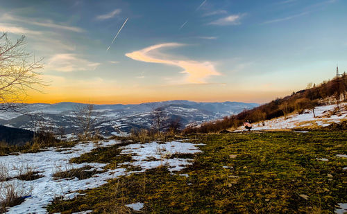 Scenic view of snowcapped mountains against sky during sunset