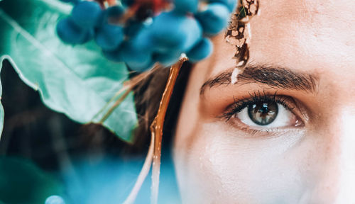 Close-up portrait of woman by plant