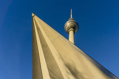 Low angle view of fernsehturm tv tower against blue sky